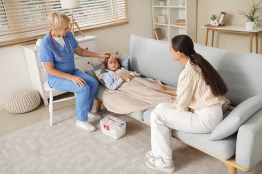 Female pediatrician working with ill little girl and mother at home clipart