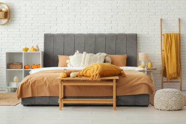 Yatak odasının içi rahat yatak odası, bank, raf ünitesi ve balkabaklı merdiven.