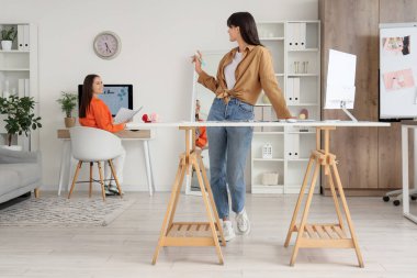 Ofisteki masalarda çalışan kadın düğün organizatörleri.