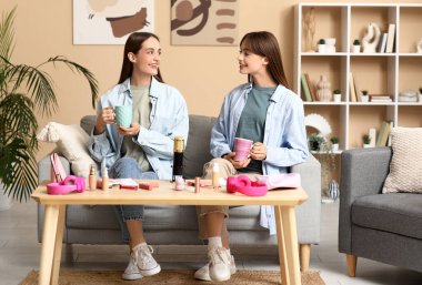 Evde podcast kaydeden çay ve makyaj ürünleriyle genç kız kardeşler