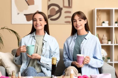 Evde podcast kaydeden çay ve makyaj ürünleriyle genç kız kardeşler