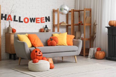 Cadılar Bayramı partisi için dekore edilmiş kanepe, balkabağı ve disko topu olan şık bir oturma odası.