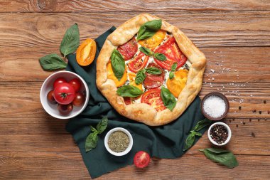 Lezzetli domates galeti, taze fesleğen ve ahşap arka planda baharatlar ile kompozisyon