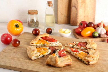 Beyaz arka planda lezzetli domates galetesi parçaları olan ahşap tahta tahta tahta.