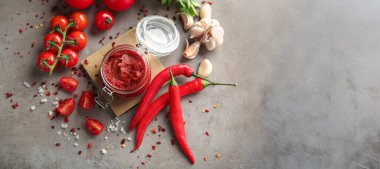 Gri arkaplan üzerine domates sosu ve malzeme kavanozu metin ve üst görünüm için boşluk