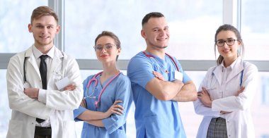 Klinikteki pencerenin yanında genç doktorlar var.