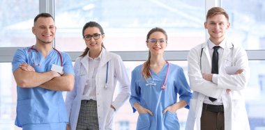 Klinikteki pencerenin yanında genç doktorlar var.