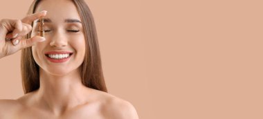 Gülümseyen genç kadın bej arka planda ampul tutuyor ve mesaj için yer var.