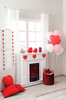 Interior of festive living room with fireplace, pouf and decorations for Valentine's Day celebration clipart