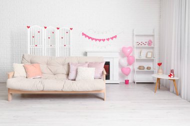 Beyaz kanepeli, şömineli ve Sevgililer Günü kutlaması için dekorlu festival salonu.