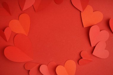 Kırmızı arka planda kağıt kalplerden yapılmış bir çerçeve. Sevgililer Günü kutlaması