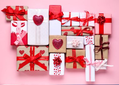 Pembe arka planda Sevgililer Günü kutlaması için farklı hediye kutularıyla kompozisyon