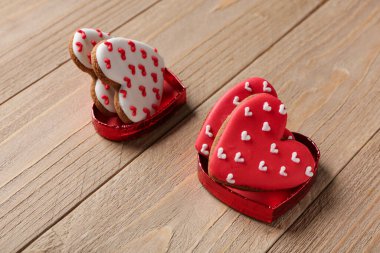 Ahşap arka planda kalp şeklinde kurabiyeler olan kutular. Sevgililer Günü kutlaması