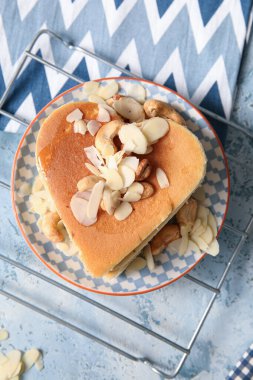 Kalp şeklinde lezzetli gözlemeler ve mavi arka planda fındıklar. Sevgililer Günü kutlaması