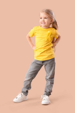 Kahverengi arka planda sarı kurdeleli şirin küçük kız. Çocukluk kanseri farkındalığı