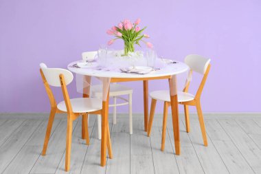 Yemek masası ve lale çiçekleri odadaki renk duvarının yanında Uluslararası Kadınlar Günü kutlamalarında servis edildi.