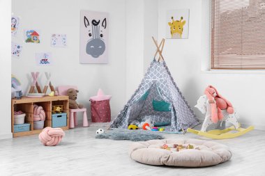 Modern oyun odasının şık bir iç mekanı, büyük bir pouf ve çadır.