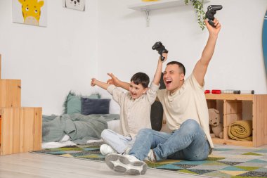 Mutlu küçük çocuk ve babası yatak odasında oyun oynuyorlar.