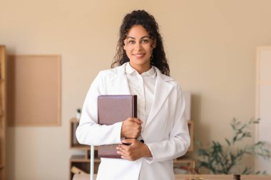 Female African-American lawyer with notebook in office clipart