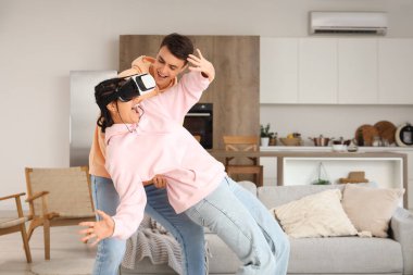 Evde VR gözlük takan genç bir çift.