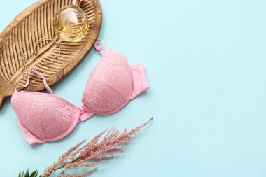 Renkli arka planda şık kadın sütyeni, aksesuar ve çiçek kompozisyonu