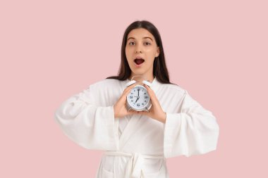 Pembe arka planda alarmlı genç kadın şok oldu.