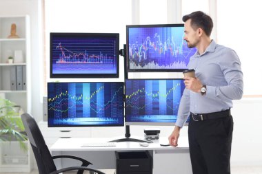 Ofiste çalışan kahve fincanı olan bir erkek tüccar.