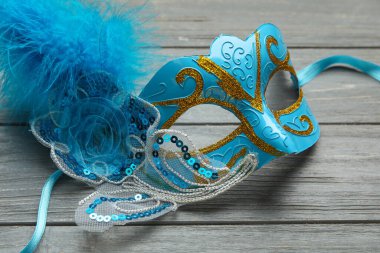 Gri ahşap arka planda güzel mavi bir karnaval maskesi. Yakın çekim.