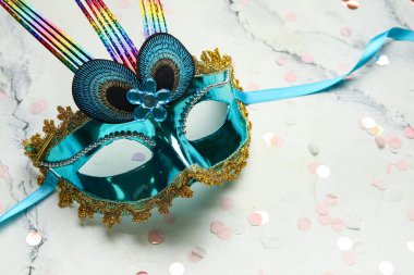 Beyaz arka planda konfeti olan güzel mavi bir karnaval maskesi. Yakın çekim.