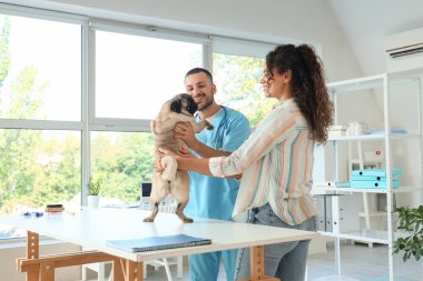 Klinikte sahibi ve köpeği olan bir erkek veteriner.