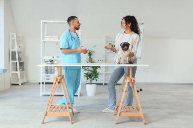 Erkek veteriner klinikte sahibi ve köpeğiyle çalışıyor.