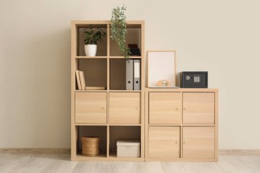 Güvenlik kutusu ve kumbarası olan raflar beyaz duvarın yanında.