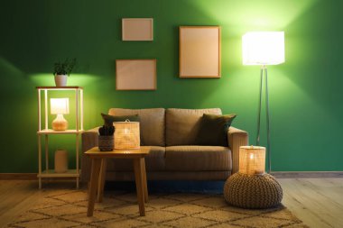 Konforlu kanepe, kahve masası ve oturma odasının içinde parlayan lambalar.