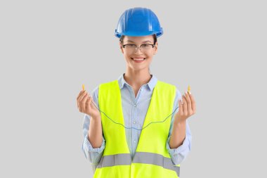 Hafif arka planda kulak tıkaçları olan kadın geliştirici