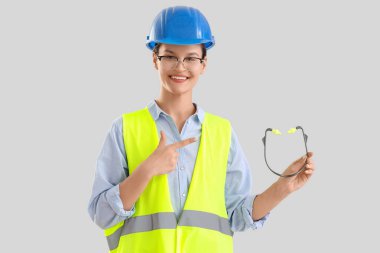 Hafif arka planda kulak tıkaçları olan kadın geliştirici