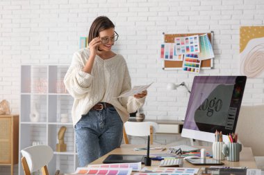 Ofisinde renk örnekleri olan genç bir kadın grafik tasarımcısının portresi