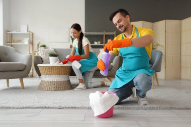 Odada deterjan temizleyen erkek hademe.