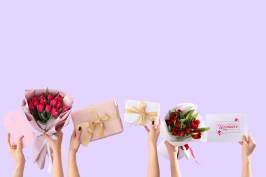 Lale buketli kadın elleri, şenlikli kartpostal ve leylak arkaplanlı hediye kutuları. Uluslararası Kadınlar Günü için Alışveriş