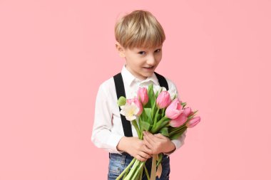 Pembe arka planda bir buket güzel lalesi olan sevimli küçük bir çocuk. Uluslararası Kadınlar Günü