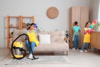 Sevimli küçük çocuklar yorgun annelerine evde temizlik işlerinde yardım ediyorlar.