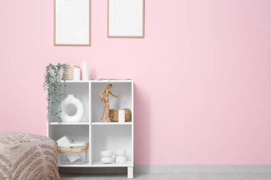 Odanın içinde raf ünitesi, boş çerçeveler ve yanan mumlar var.