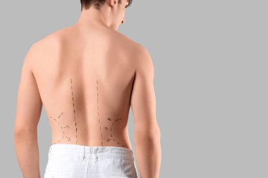 Sırtında gri arka planı olan genç bir adam. Estetik ameliyat konsepti