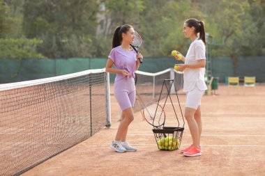 Tenis kortunda konuşan genç kadınlar