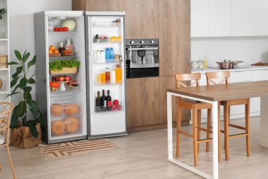 Modern mutfakta taze yiyeceklerle dolu bir buzdolabı.