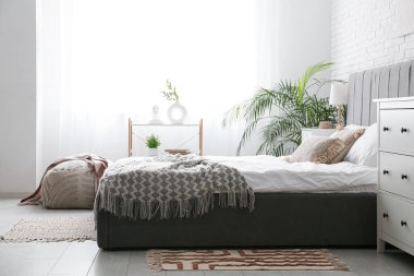 Geniş yataklı ve pencereli modern yatak odasının içi