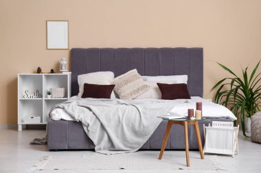 Rahat yatağı ve yanan mumları olan modern bir yatak odası.