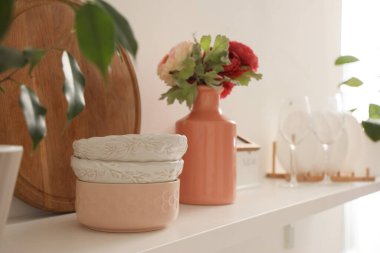 Mutfakta tezgahta çiçekler olan kâseler, yemek ve vazolar. Yakın çekim.