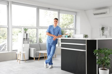 Kliniğin resepsiyonunda erkek stajyer.