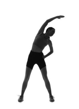 Beyaz arka planda uzanan genç ve sportif bir kadının silueti.