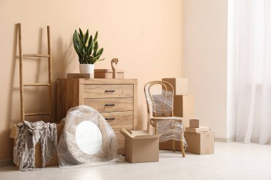 Yeni oturma odası. İçinde çekmeceler, aynalar ve karton kutular var. Taşınma konsepti